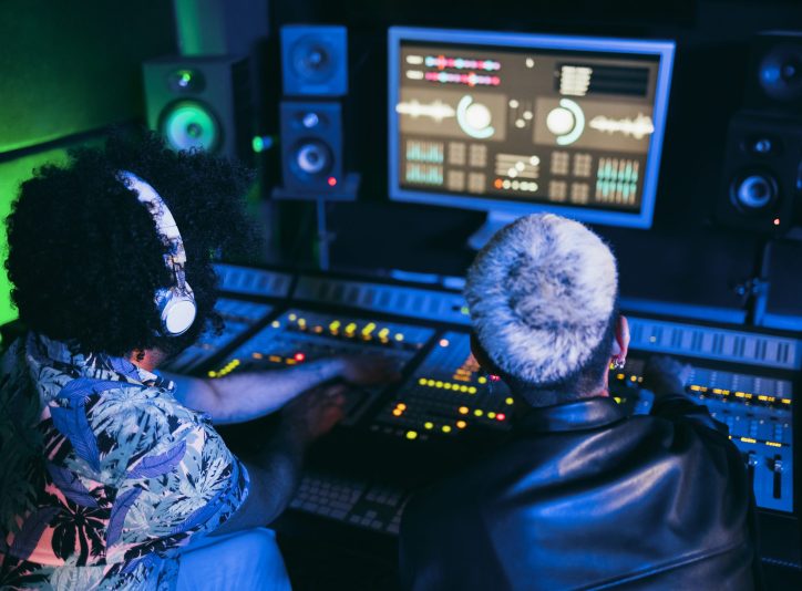 Musician and sound engineer mixing new album inside boutique recording studio - Soft focus on man headphones